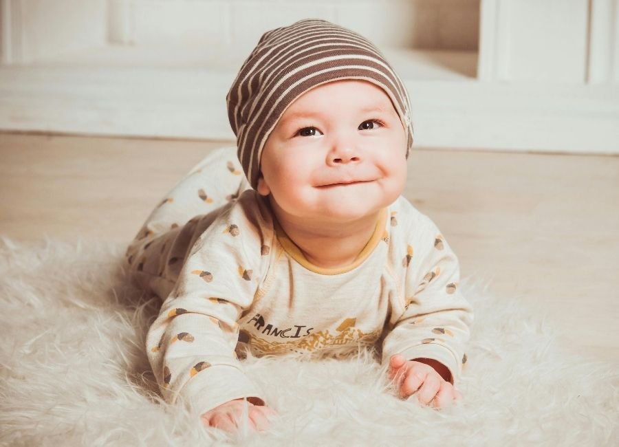Bebê de poucos meses fazendo tummy time, levantando a cabecinha com apoio e carinho, estimulando o fortalecimento do pescoço e o desenvolvimento motor nos primeiros meses